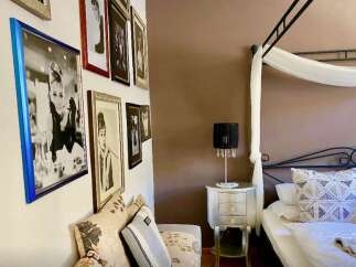 This charming bedroom features a gallery wall with elegant framed artwork.