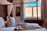 Experience luxury in this stunning bedroom with a four-poster bed and elegant decor.
