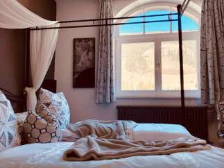 Experience luxury in this stunning bedroom with a four-poster bed and elegant decor.