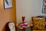 Discover the charm of this cozy corner, featuring elegant seating and a vintage sewing machine wall decor.