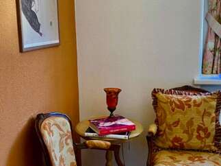 Discover the charm of this cozy corner, featuring elegant seating and a vintage sewing machine wall decor.