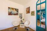 Discover a charming corner with artistic flair! This space features elegant white chairs, perfect for relaxation.