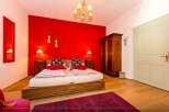 Discover a cozy bedroom with a vibrant red accent wall, creating a warm and inviting atmosphere.