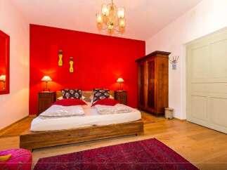Discover a cozy bedroom with a vibrant red accent wall, creating a warm and inviting atmosphere.