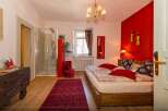 This charming bedroom boasts a vibrant red accent wall, creating a warm and inviting atmosphere.