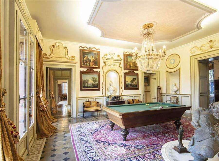 This luxurious estate boasts a stunning game room, complete with a classic billiard table and exquisite antique furnishings.