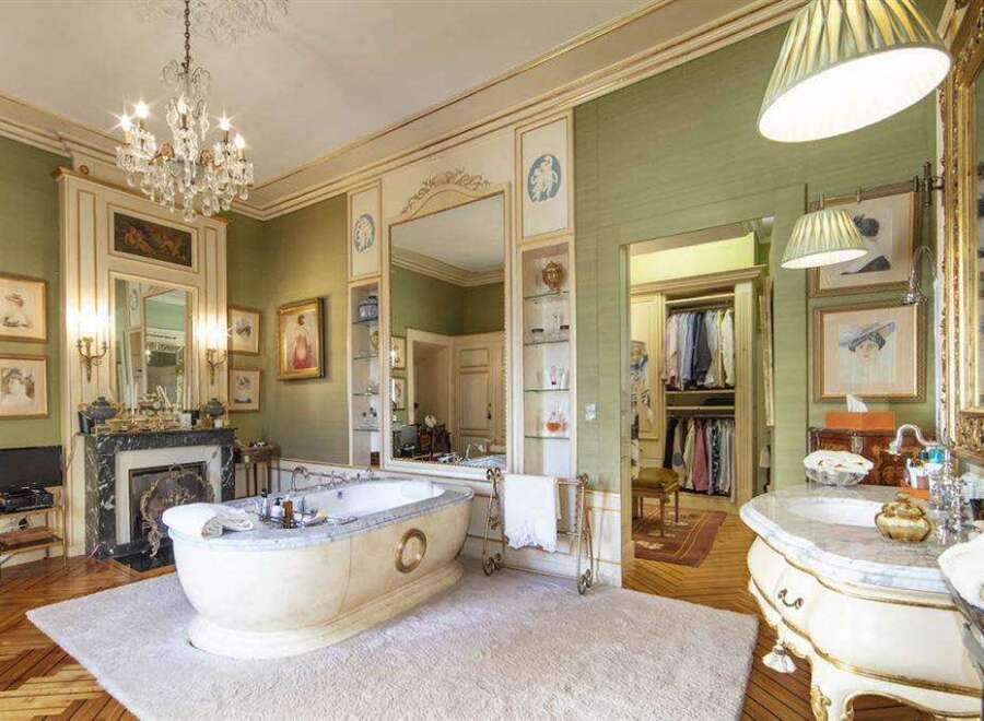 This luxurious bathroom boasts a freestanding tub, marble vanity, and ornate details.