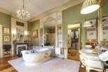 This luxurious bathroom boasts a freestanding tub, marble vanity, and ornate details.