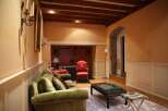This luxurious living room boasts a stunning wooden beam ceiling, plush velvet sofas, and antique-style decor.