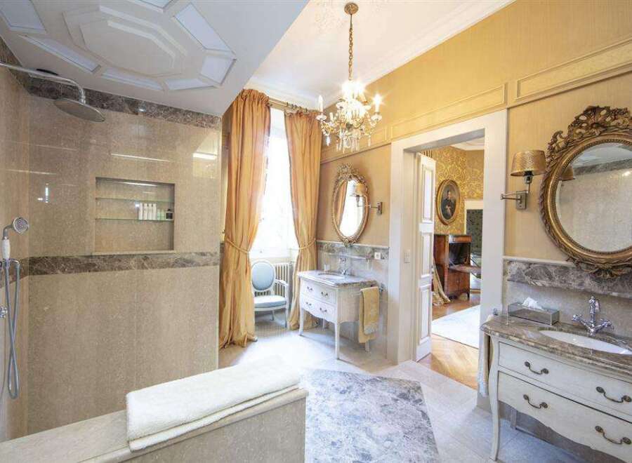 Luxury bathroom with marble finishes, a walk-in shower, and a freestanding bathtub.