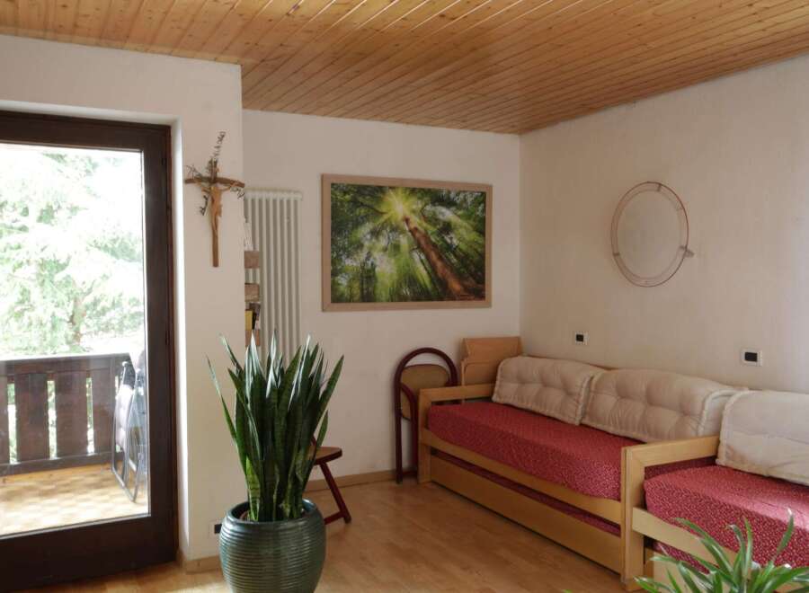 This cozy living space features a warm wooden ceiling and a comfortable daybed, perfect for relaxation.