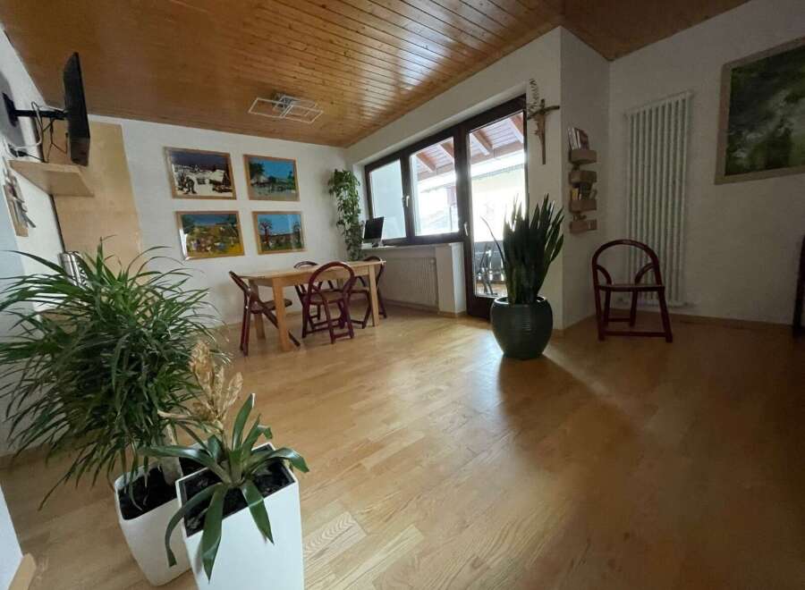This charming living space features a warm wooden ceiling and flooring, creating a cozy atmosphere.