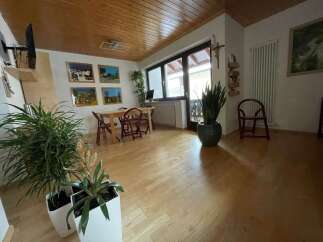 This charming living space features a warm wooden ceiling and flooring, creating a cozy atmosphere.