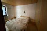 Cozy bedroom with a wooden ceiling and a comfortable bed.