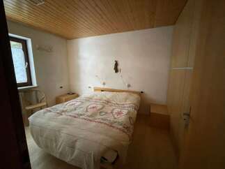 Cozy bedroom with a wooden ceiling and a comfortable bed.