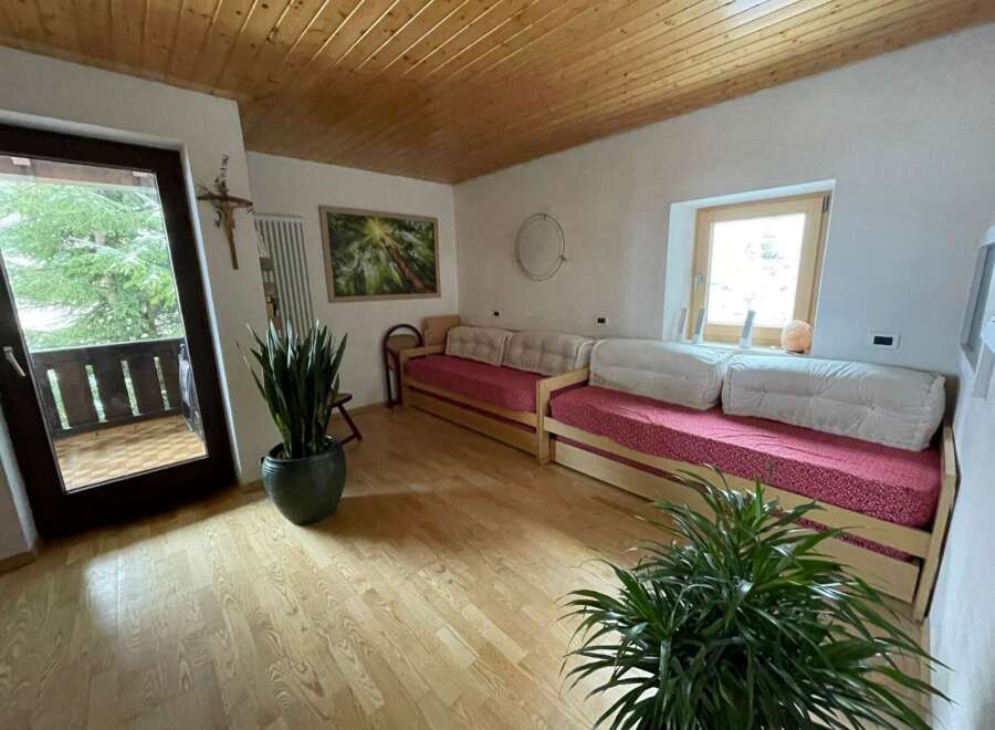 This cozy living space features a warm wooden ceiling and flooring, creating a welcoming atmosphere.