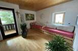 This cozy living space features a warm wooden ceiling and flooring, creating a welcoming atmosphere.