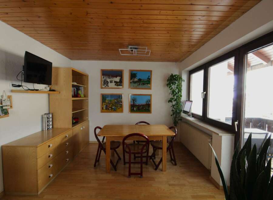 This charming dining area features a warm wooden ceiling and flooring, creating a cozy atmosphere.