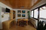 This charming dining area features a warm wooden ceiling and flooring, creating a cozy atmosphere.