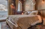 Cozy chalet bedroom with stunning mountain views.
