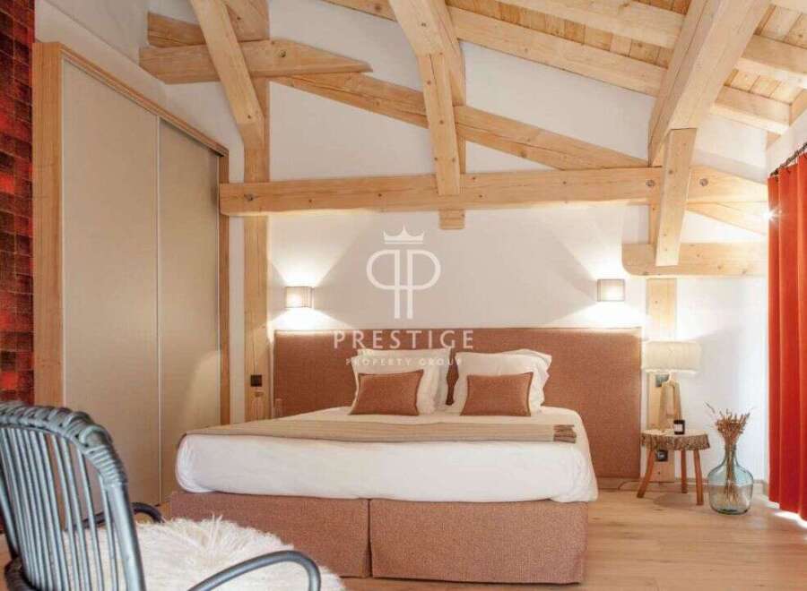 Experience luxury in this stunning bedroom featuring exposed wooden beams and a cozy ambiance.
