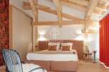 Experience luxury in this stunning bedroom featuring exposed wooden beams and a cozy ambiance.