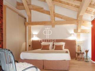 Experience luxury in this stunning bedroom featuring exposed wooden beams and a cozy ambiance.