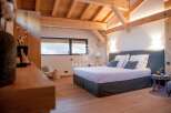 Experience luxury in this stunning bedroom featuring a cozy bed with plush pillows and a stylish headboard.