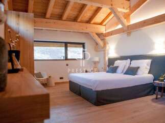 Experience luxury in this stunning bedroom featuring a cozy bed with plush pillows and a stylish headboard.