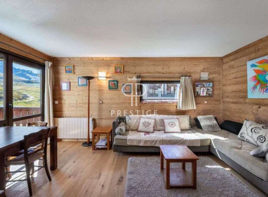 Discover the charm of this cozy living space, featuring stunning wooden paneling and a comfortable seating area.