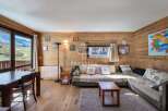 Discover the charm of this cozy living space, featuring stunning wooden paneling and a comfortable seating area.