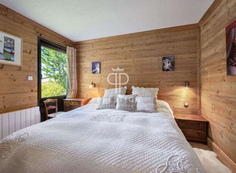 Cozy bedroom with wooden walls and a comfortable bed.