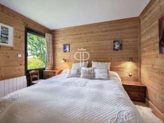 Cozy bedroom with wooden walls and a comfortable bed.