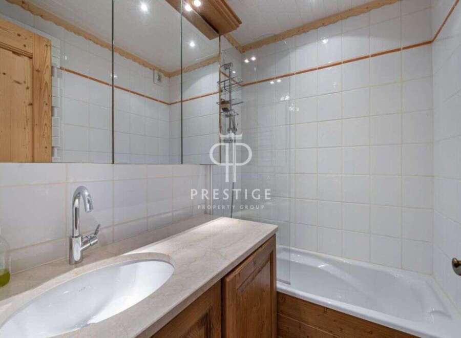 Discover a beautifully designed bathroom featuring a sleek sink and a relaxing bathtub.