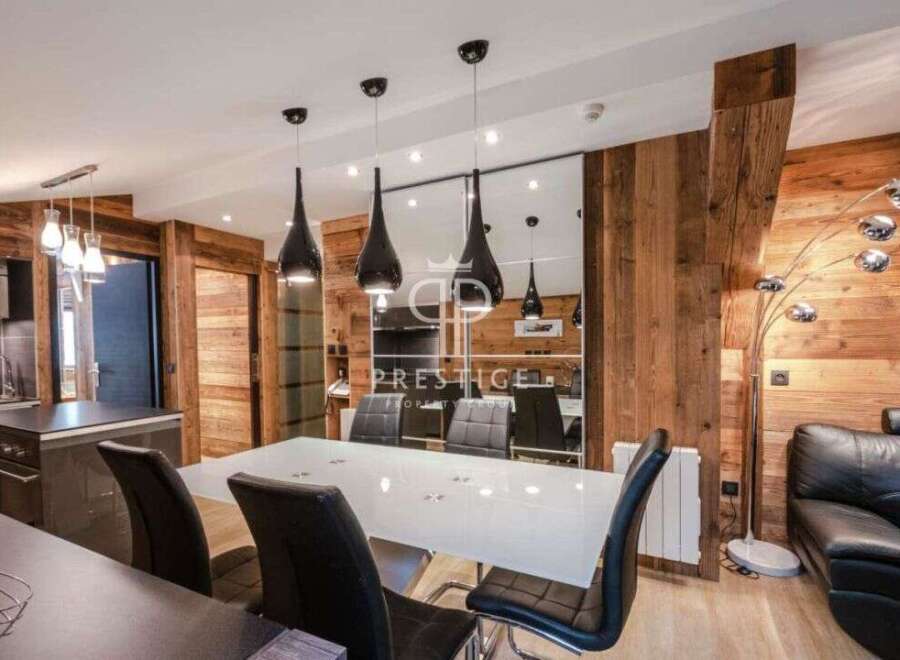 Experience luxury living in this stunning property, featuring a modern dining area with sleek black pendant lights and a stylish white table.