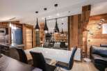 Experience luxury living in this stunning property, featuring a modern dining area with sleek black pendant lights and a stylish white table.