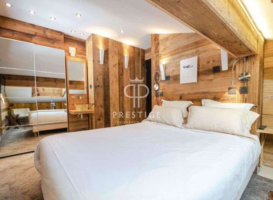 Experience luxury in this stunning bedroom featuring exquisite wooden paneling and a cozy ambiance.