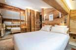 Experience luxury in this stunning bedroom featuring exquisite wooden paneling and a cozy ambiance.