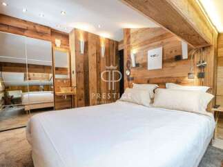 Experience luxury in this stunning bedroom featuring exquisite wooden paneling and a cozy ambiance.