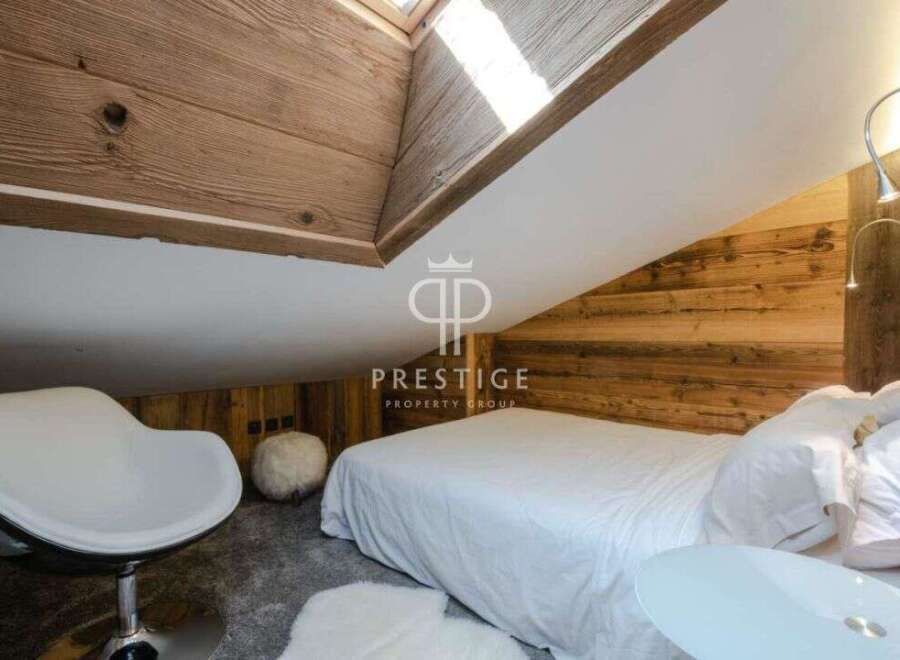 Discover the charm of this cozy bedroom, featuring a unique wooden sloped ceiling and walls.