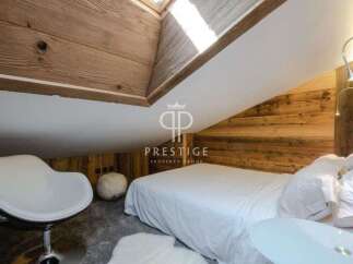 Discover the charm of this cozy bedroom, featuring a unique wooden sloped ceiling and walls.