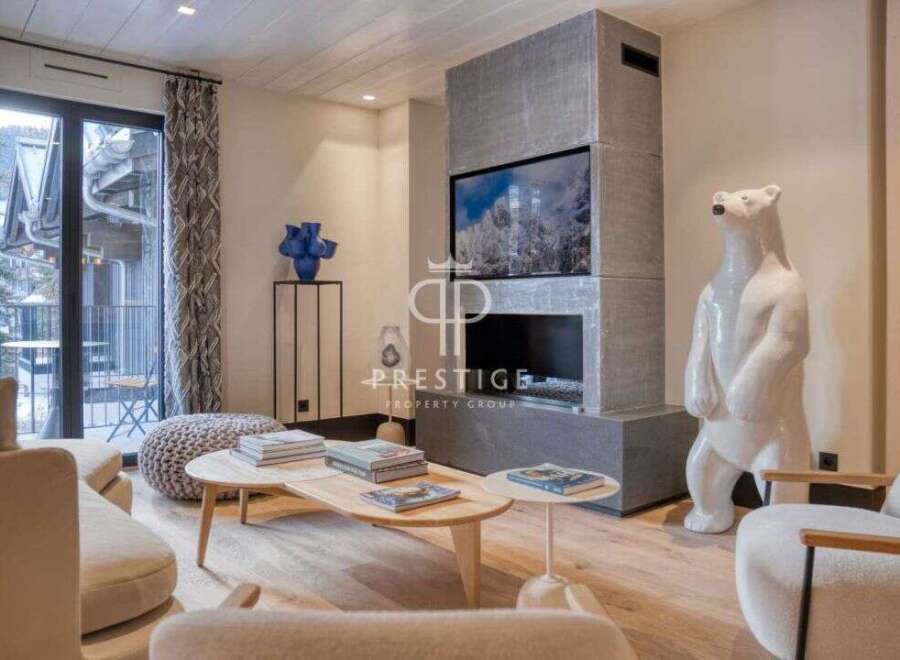 Experience luxury living in this stunning property, featuring a modern fireplace and a unique polar bear statue.