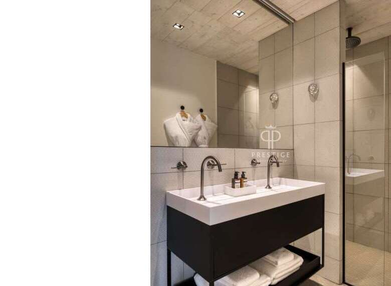 This modern bathroom boasts a sleek design with a double vanity and a spacious shower.