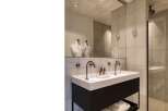 This modern bathroom boasts a sleek design with a double vanity and a spacious shower.
