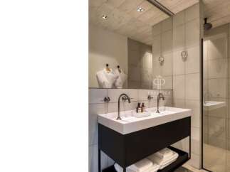 This modern bathroom boasts a sleek design with a double vanity and a spacious shower.