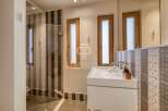 Discover a modern bathroom design with a sleek white vanity and stylish patterned tiles.
