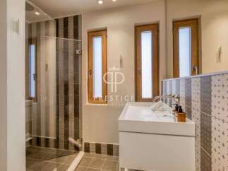 Discover a modern bathroom design with a sleek white vanity and stylish patterned tiles.