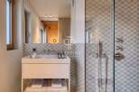 Discover a modern bathroom design featuring a sleek white vanity and a stylish glass-enclosed shower.