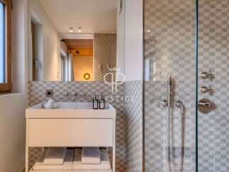 Discover a modern bathroom design featuring a sleek white vanity and a stylish glass-enclosed shower.
