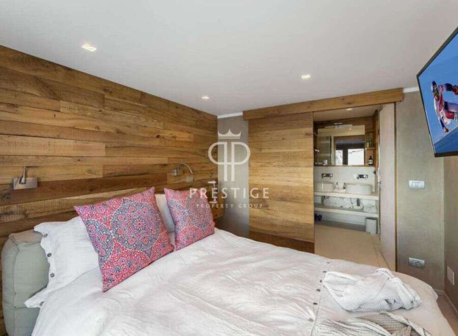 Experience luxury in this stunning bedroom featuring a unique wooden accent wall.